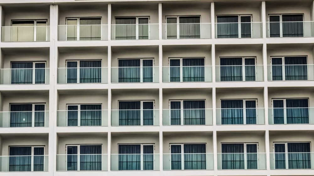 Bộ phụ kiện cửa nhôm gồm bản lề, tay nắm và khóa đa điểm đặt trên bàn xưởng